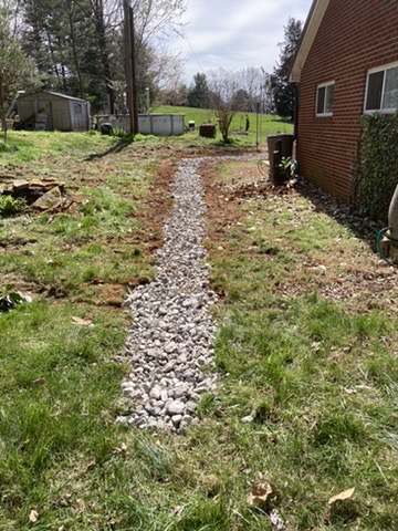 Finished French drain protecting a brick home from standing water